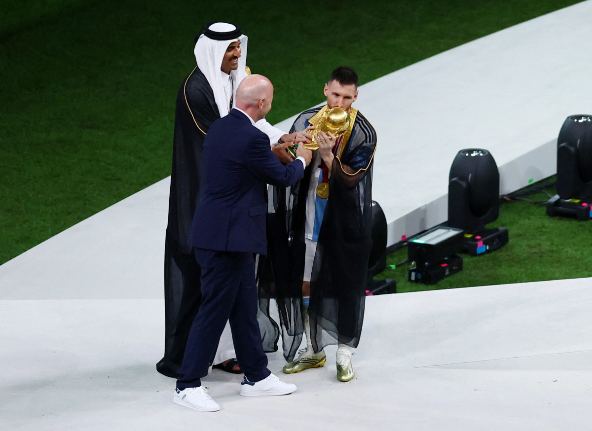 Messi trong chiếc áo choàng bisht truyền thống của Qatar, giơ cao cúp vô địch